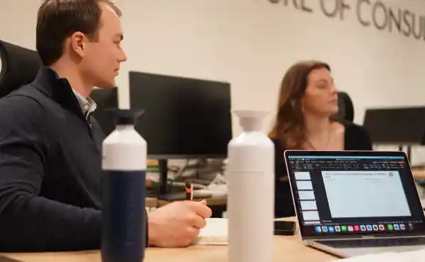Twee Student Consultants overleggen aan tafel op het kantoor in Tilburg